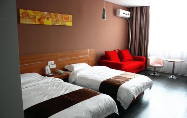 una habitación de hotel con 2 camas y una silla roja en Thank Inn Chain Hotel Jiangsu Lianyungang Donghai North Niushan Road, en Shiliushu