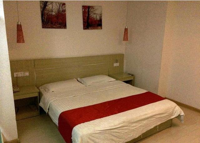 1 dormitorio con 1 cama con 2 mesas y 2 fotografías en Thank Inn Chain Hotel Jiangsu Jiangyan Pedestrian Street en Taizhou