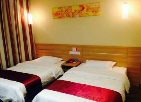 ein Hotelzimmer mit 2 Betten und einem Tisch in der Unterkunft Thank Inn Chain Hotel Henan Puyang Taiqian Train Station in Dayuchen