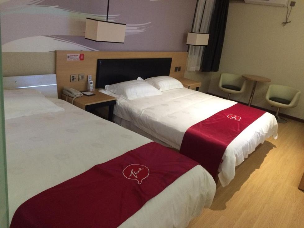 een hotelkamer met 2 bedden met rode en witte lakens bij JUNYI Hotel Jiangsu Nanjing University of Information Science and Technology in Nanjing