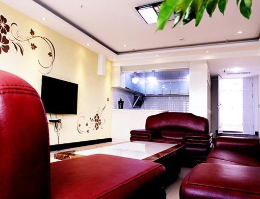 Il comprend un salon doté d'un mobilier en cuir rouge et d'une télévision à écran plat. dans l'établissement Thank Inn Chain Hotel Shanxi Jinzhong Shouyang Chaoyang Road, à Shouyang
