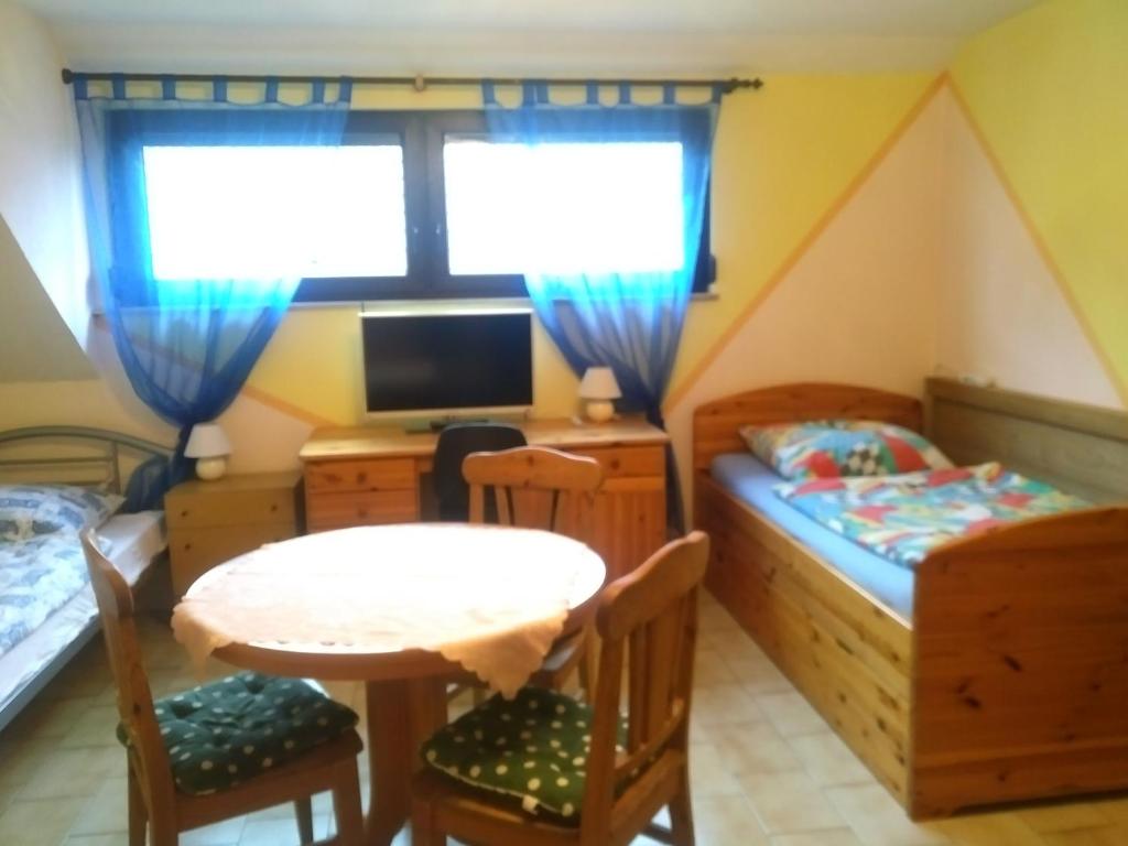 1 dormitorio con mesa, cama y escritorio en Bea's Monteurzimmer, en Seckach