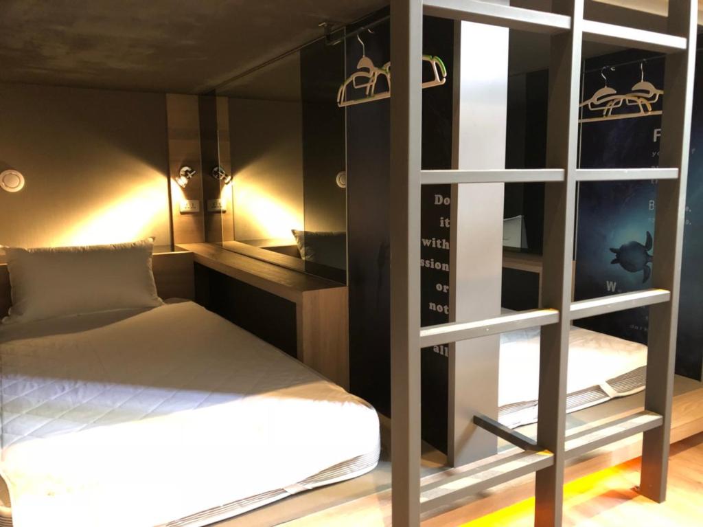 a room with a bed and a room with a mirror at Taipei Discover Hostel in Taipei