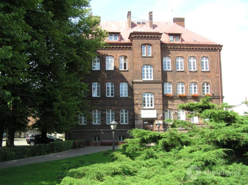 a large brick building with a car parked in front of it at Szkolne Schronisko Młodzieżowe w Gdańsku in Gdańsk