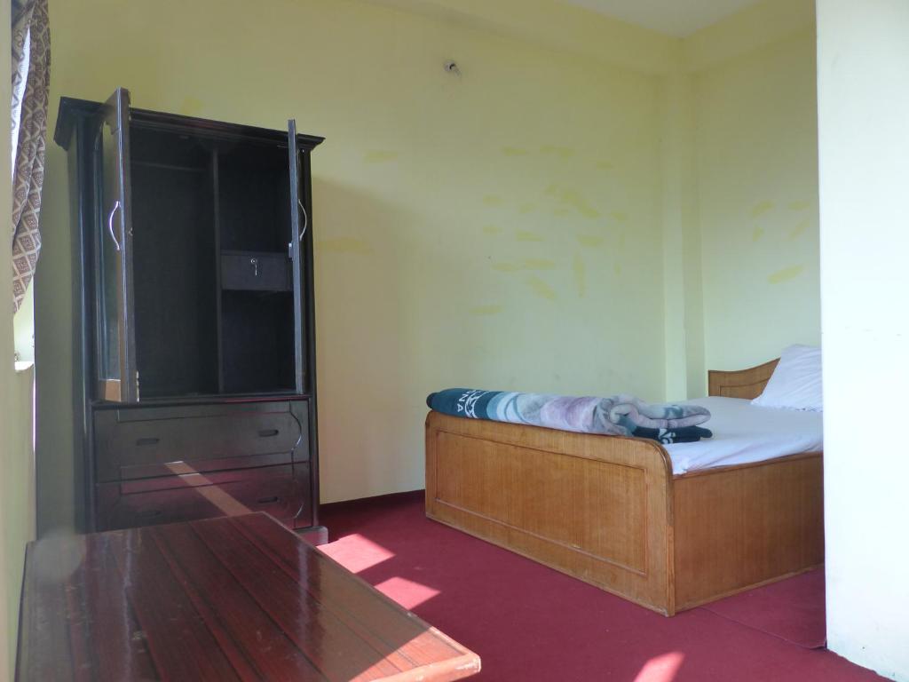 una camera con un letto e un grande televisore di Gorgeous Village Guest House a Pokhara
