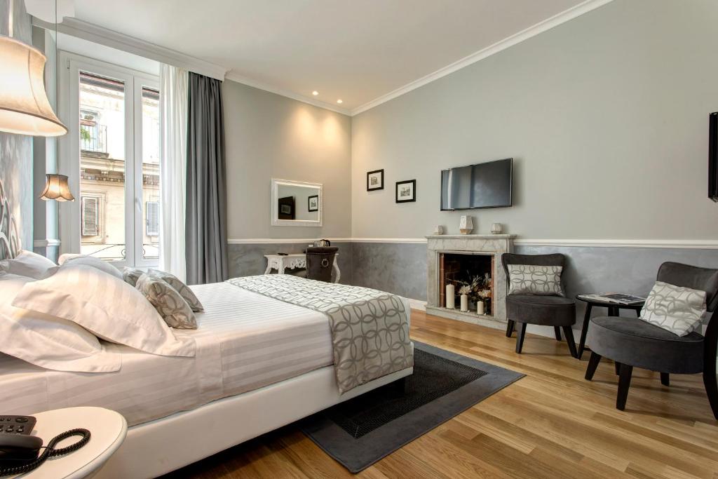 um quarto com uma cama e uma sala de estar com lareira em Relais de l'Opera - Relais de l'Opera Group em Roma