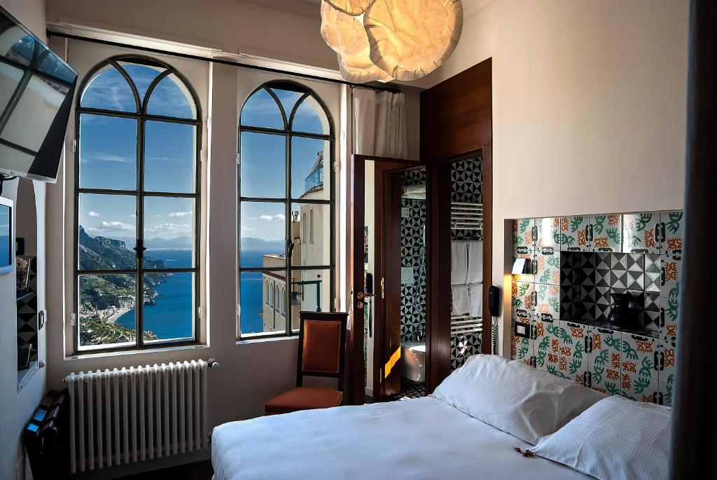 a bedroom with a bed and windows with a view at La Moresca in Ravello