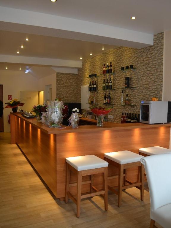 a large wooden bar in a kitchen with two stools at Altstadthotel-Rheine in Rheine