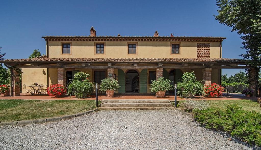 una casa grande con un gran patio delantero en Agriturismo Valliferone, en Crespina