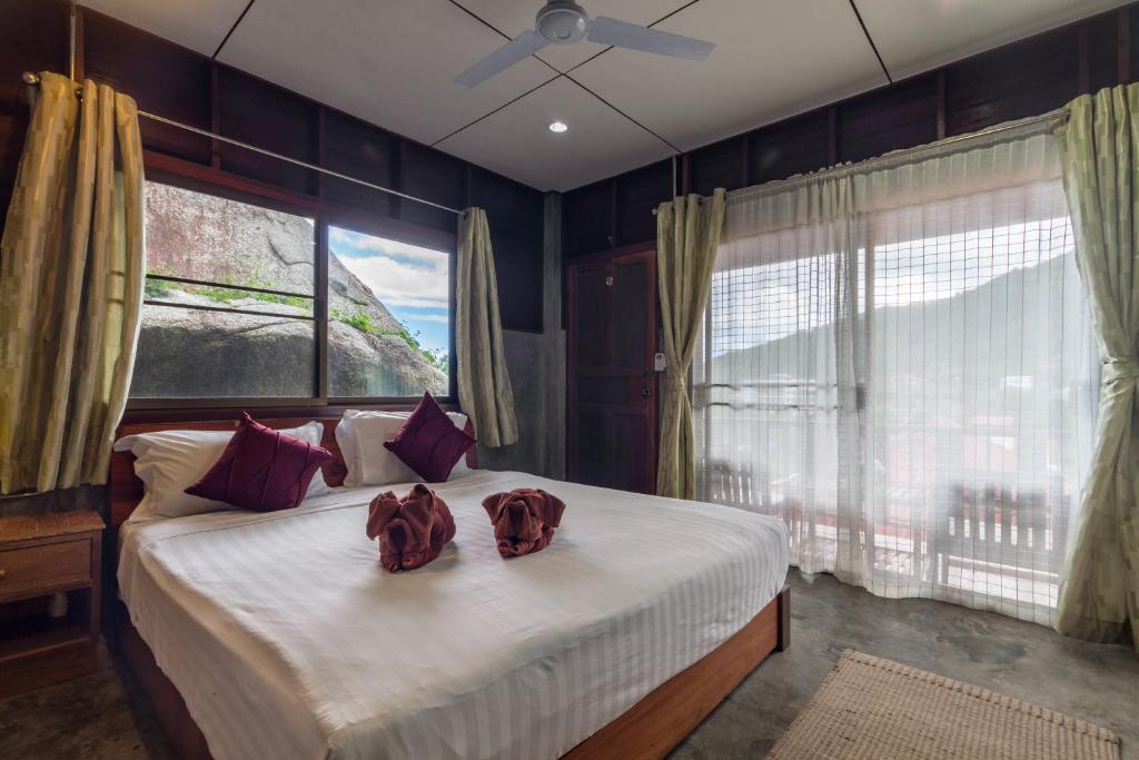 Un dormitorio con una cama grande con dos sombreros. en Kanya Cozy Bungalows Kata, en Kata Beach