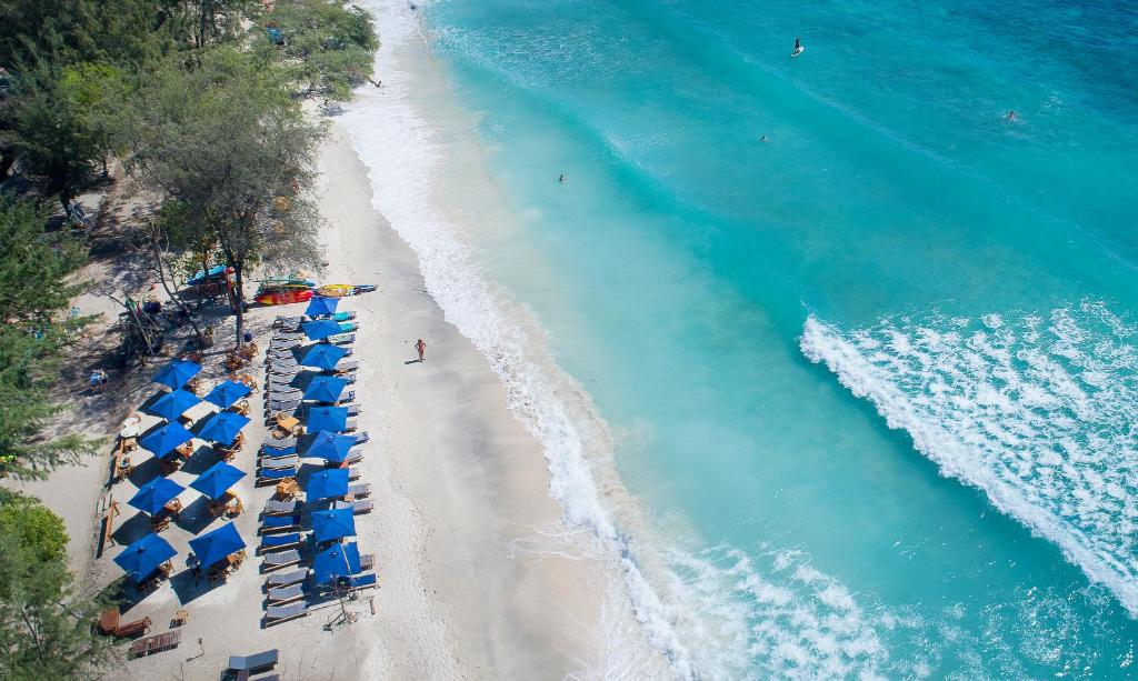 una vista aérea de una playa con sombrillas azules en Villa Almarik Resort, en Gili Trawangan