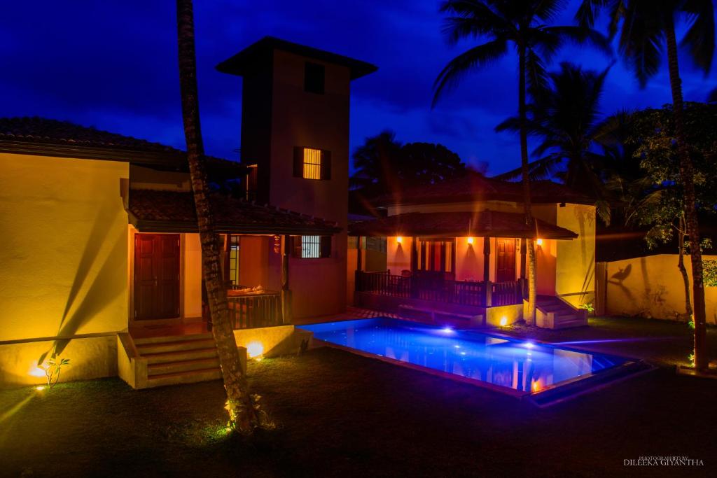 una casa con piscina por la noche en Breeze Villa Unawatuna en Galle