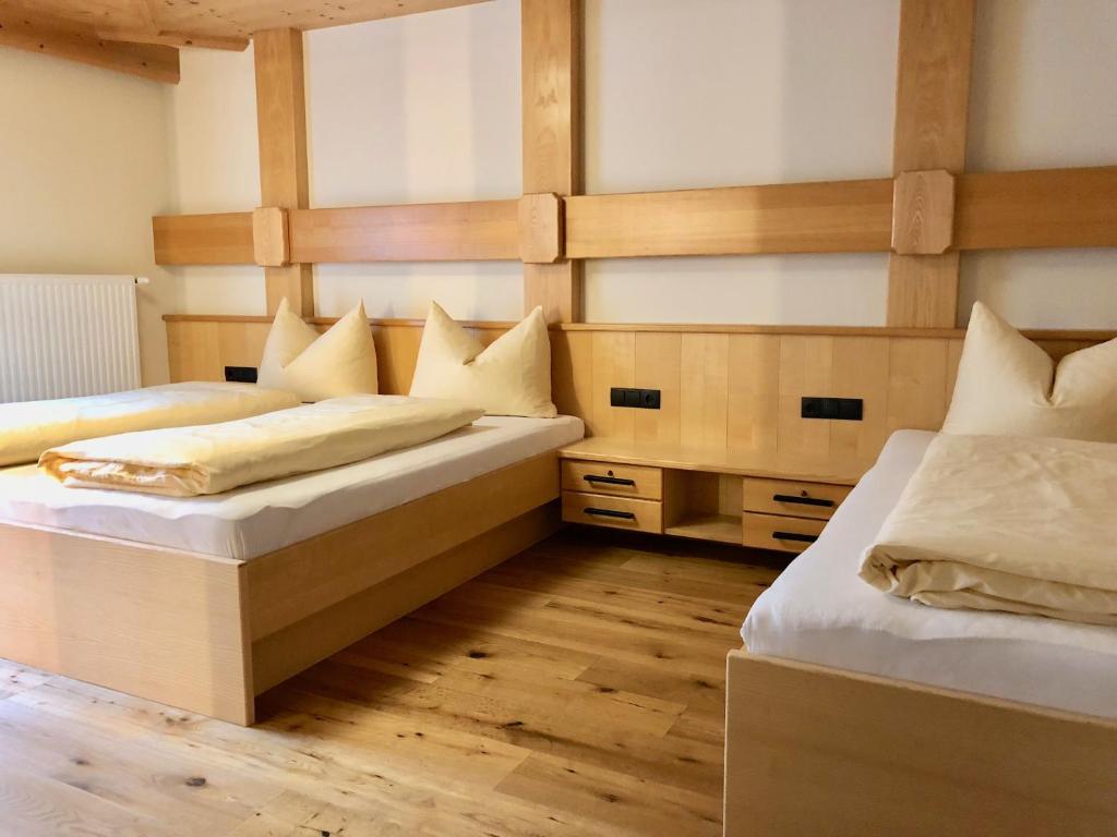 2 letti in una camera con pavimenti in legno di Apart Michaela a See