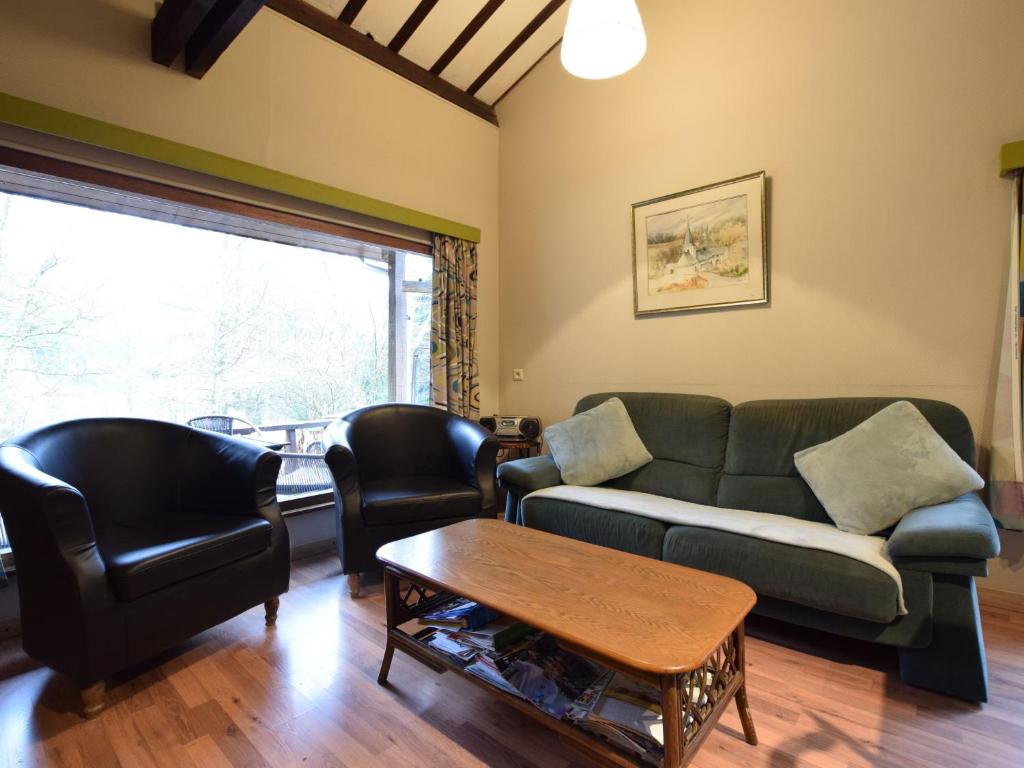 ein Wohnzimmer mit einem Sofa, Stühlen und einem Tisch in der Unterkunft detached chalet in lovely hiking region in Bellevaux