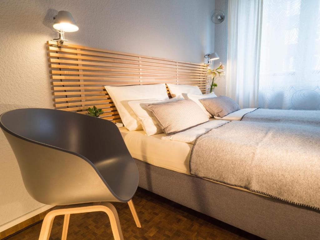 Un dormitorio con una cama con una silla al lado en MY PLACE Hotel en Hamburgo