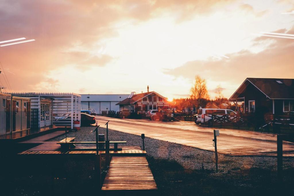 a wooden walkway leading to a parking lot with a sunset at Hotel Krutitcy in Sasykino