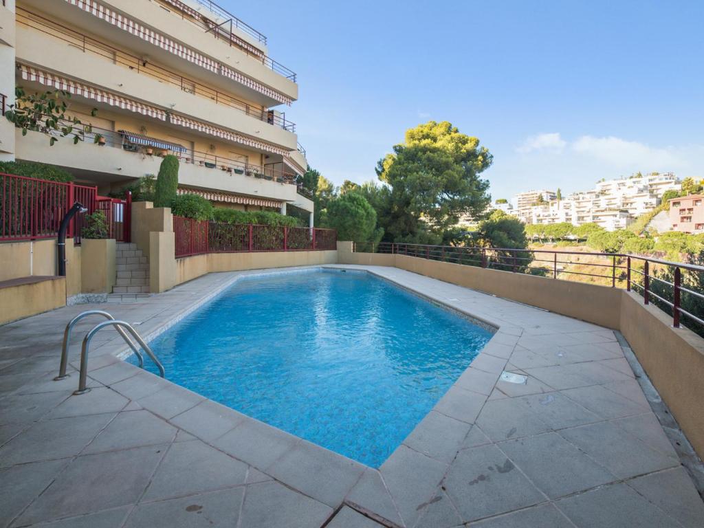 una piscina al lado de un edificio en Welkeys Apartment - Lanterne, en Niza