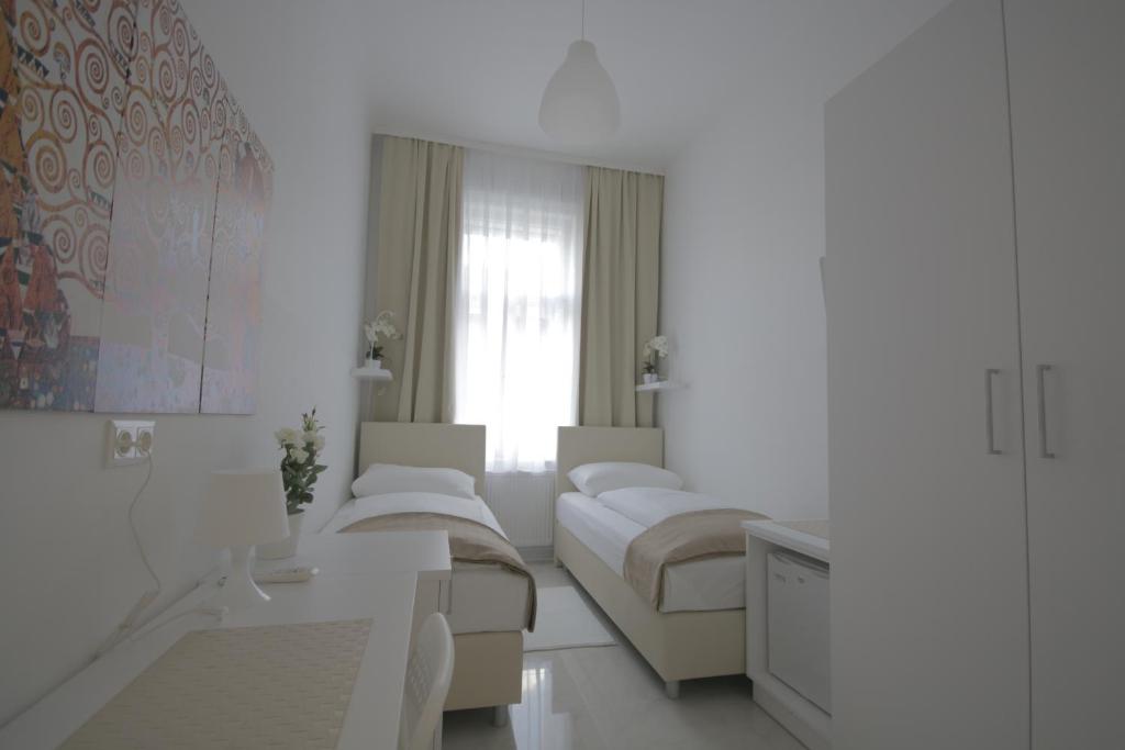 a white living room with couches and a window at CH-Hotel Luka Budget in Vienna