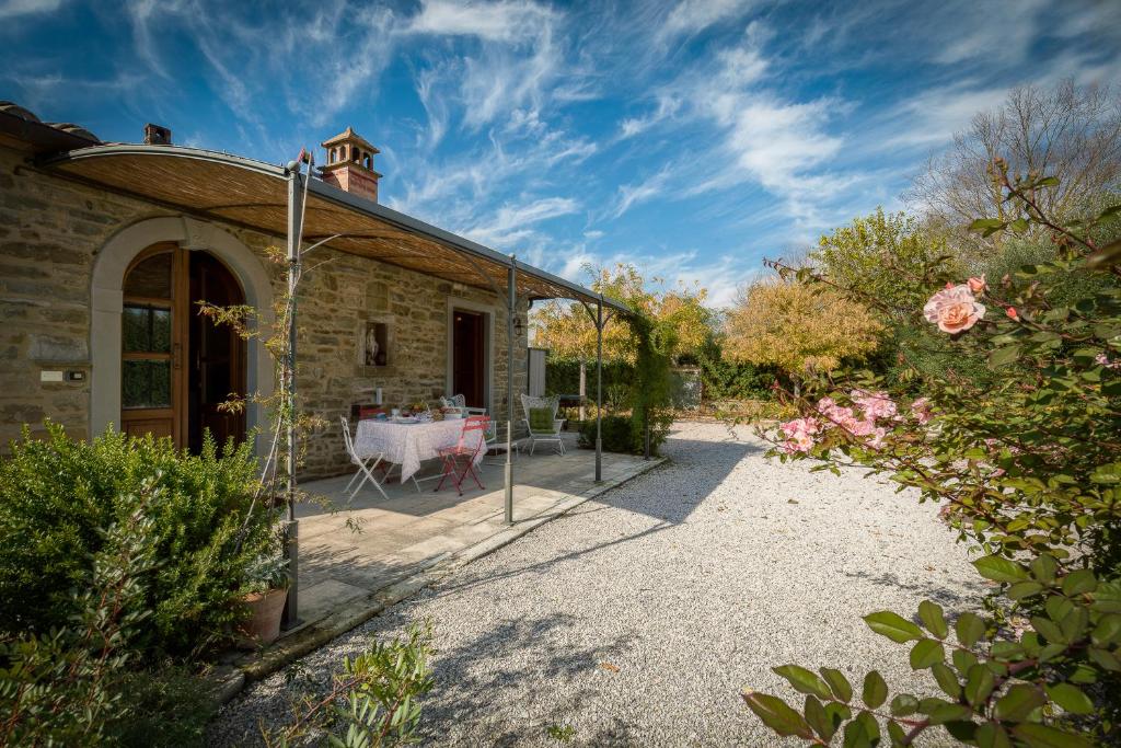 un patio con una mesa y una casa en Casina La Graziosa, en Cortona
