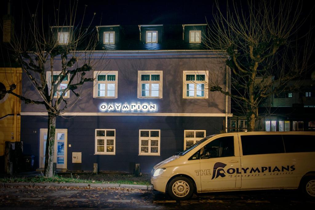ein weißer Van vor einem Gebäude geparkt in der Unterkunft Pension Olympion in Jihlava