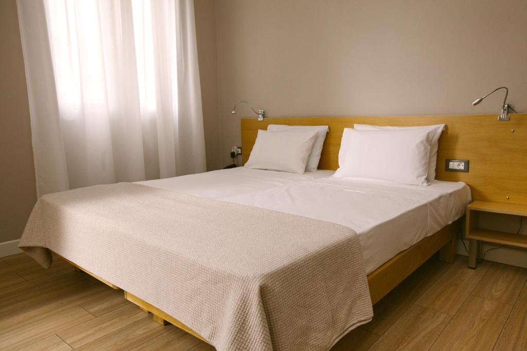 a bedroom with a large bed with white sheets at Casa Mia Apartments in Agios Nikolaos