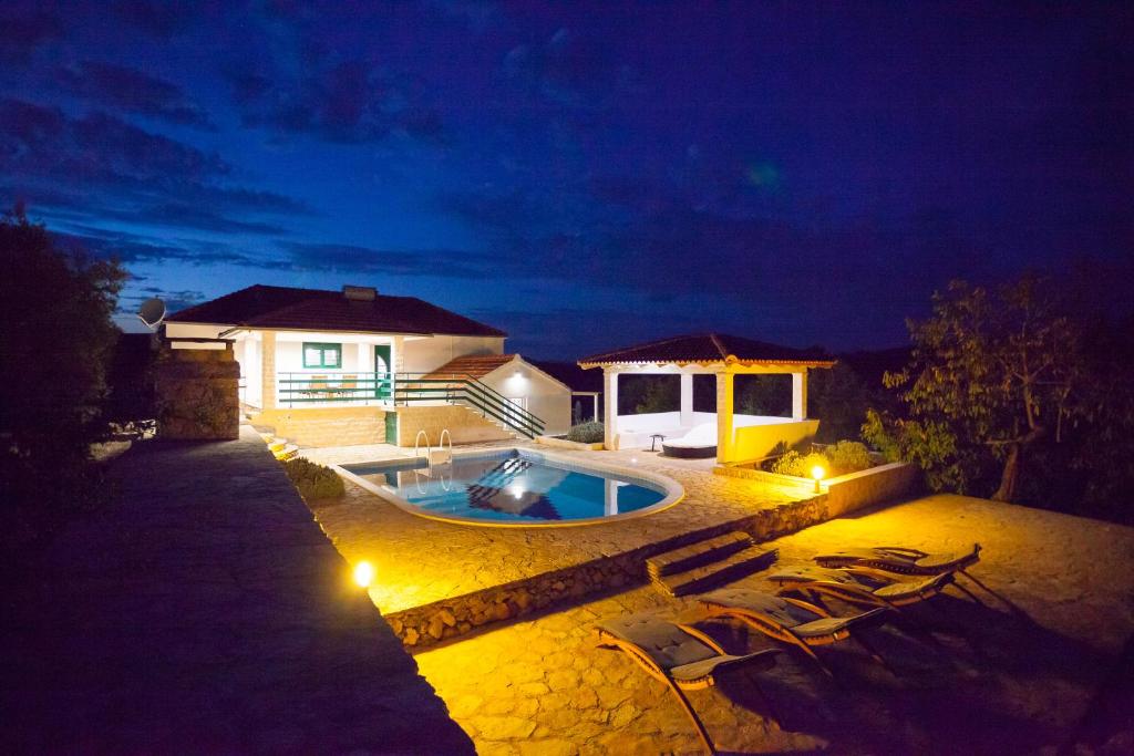 una casa con piscina di notte di House Nikita a Vela Luka (Vallegrande)