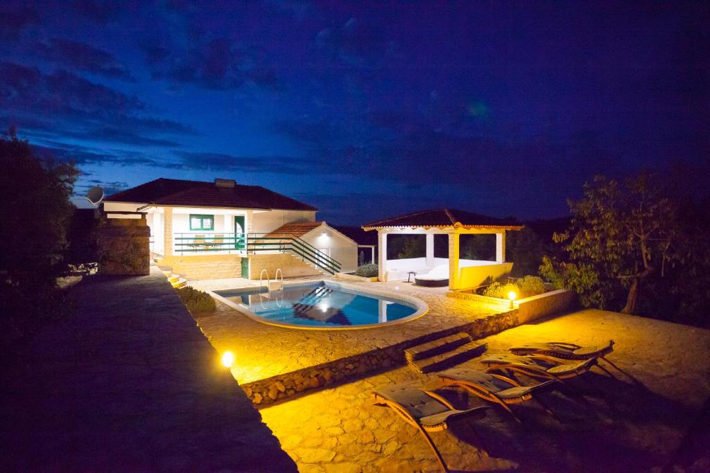 a house with a swimming pool at night at House Nikita in Vela Luka
