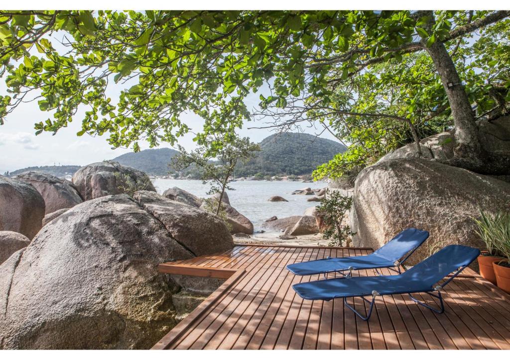 twee blauwe stoelen op een houten terras bij het water bij Paraiso in Florianópolis