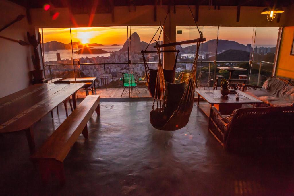 a room with a hammock and tables and a sunset at Casa 48 Guesthouse in Rio de Janeiro