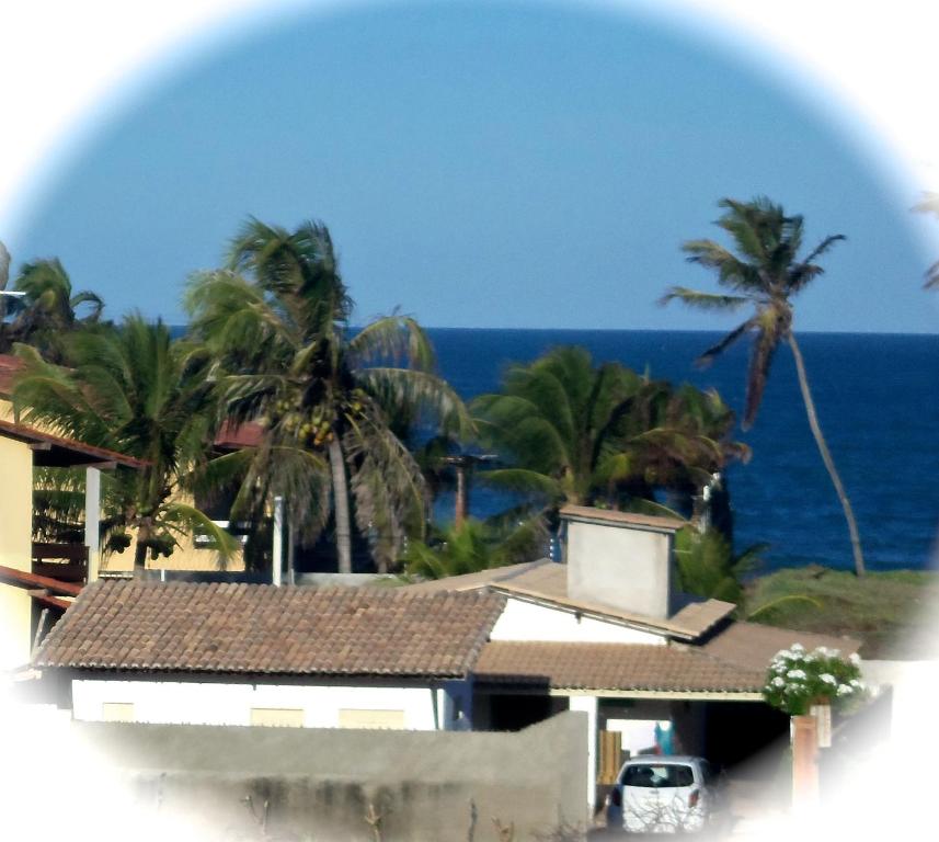 a view of a house and the ocean with palm trees at Casa na Praia de Muriu - Andréia in Muriú