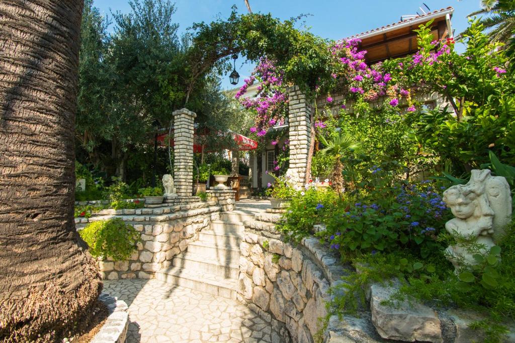 a garden with flowers and a stone path at Apartments Picolo Paradiso Miljenko Debelić in Rab