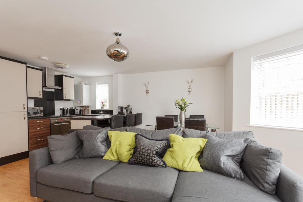 een woonkamer met een grijze bank en gele kussens bij Stunning Contemporary Apartment - Free Parking - 5 Minute Walk To The Beach - Great Location - Fast WiFi - Smart TV With Netflix Included - Perfect For Short and Long Stays in Bournemouth