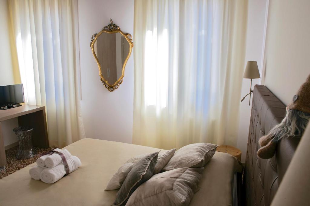 um quarto com uma cama com um espelho na parede em B&B Al Pozzo di Luce em Veneza