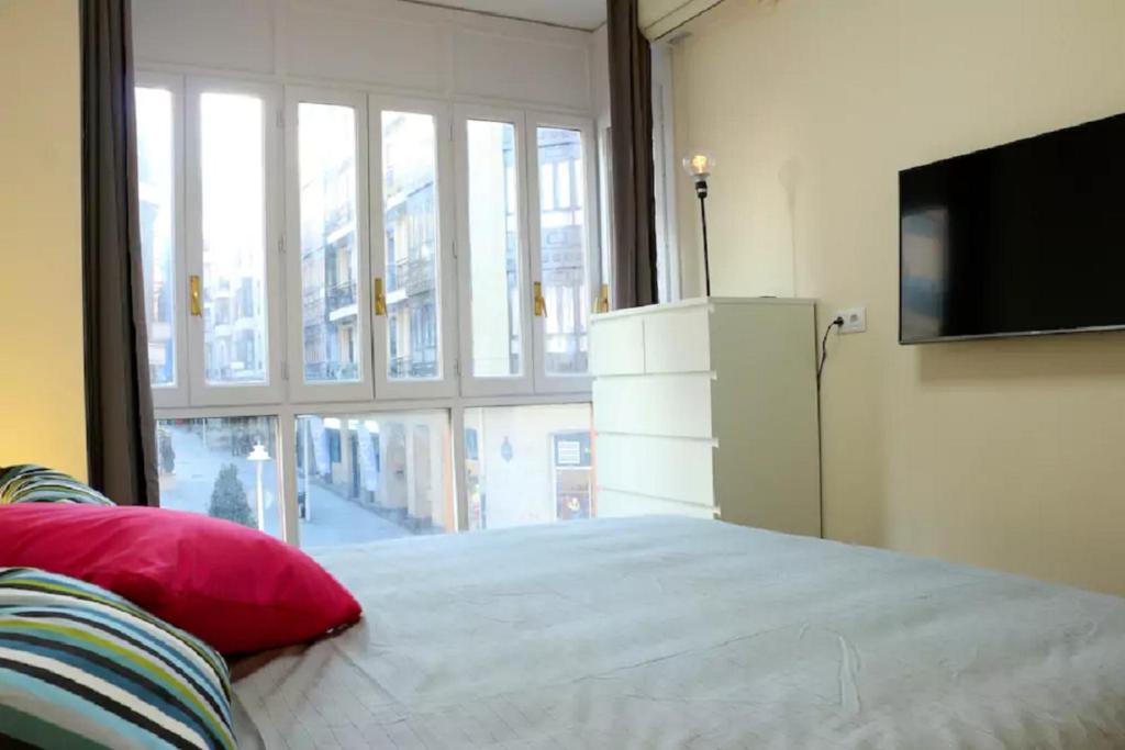 a bedroom with a bed and a large window at Apartamento Villarias in Bilbao