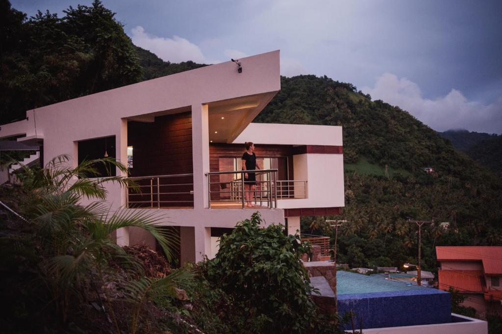 a woman standing on the balcony of a house at Sargas Villa, Saint Lucia in Colombette