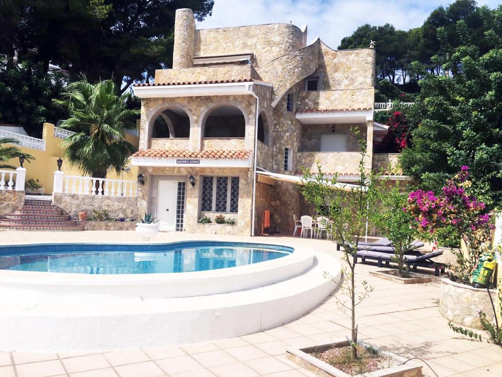 uma casa com uma piscina em frente em Villa con piscina em Oropesa del Mar