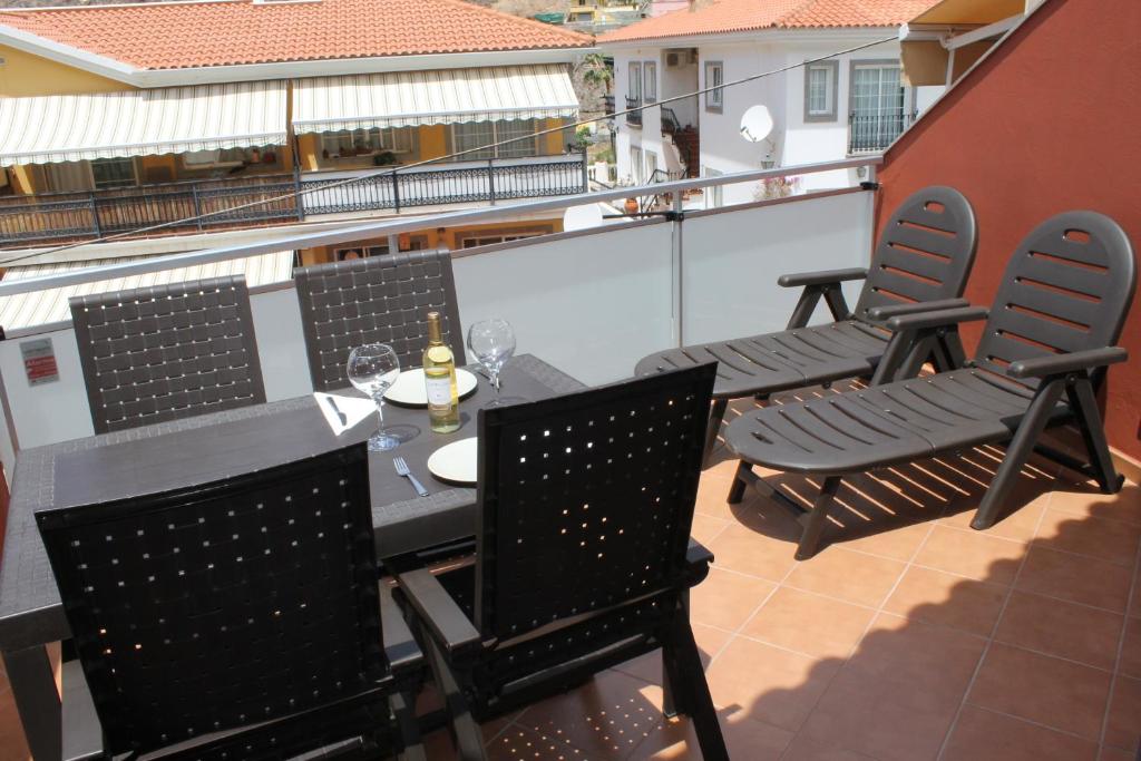 patio con mesa y sillas en el balcón en Apartamento Mele, en Puerto de Mogán