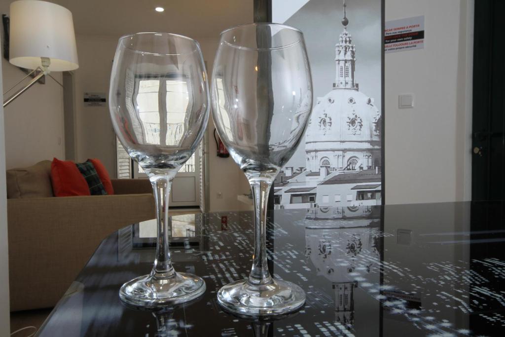 dos copas de vino sentadas sobre una mesa en Alfama Right Point, en Lisboa