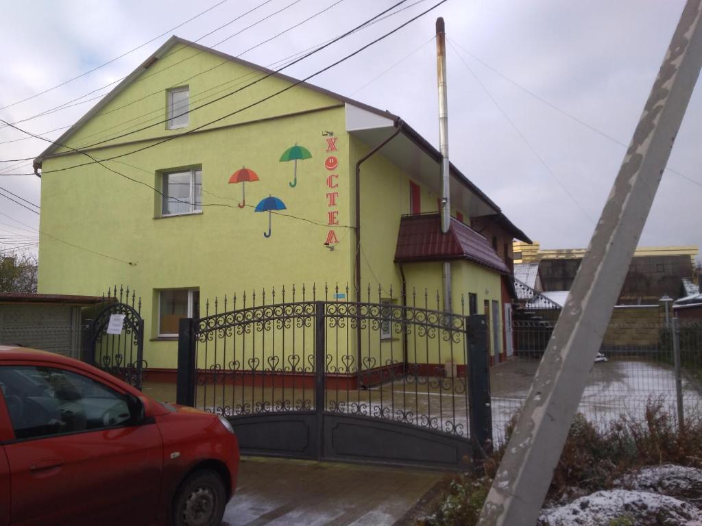 ein gelbes Haus mit seitlich bemalten Sonnenschirmen in der Unterkunft Parasolka in Luzk