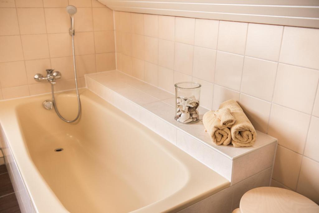 ein Badezimmer mit einer Badewanne, einem WC und Handtüchern in der Unterkunft Haus am Sonnenhügel in Thallichtenberg