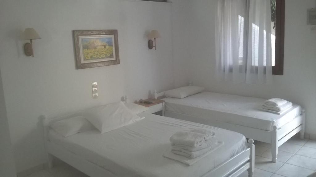a white room with two beds and a window at Aeolos Hotel Apartments in Gythio