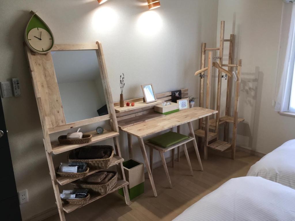 een kamer met een houten bureau en een spiegel bij Santari in Shintoku