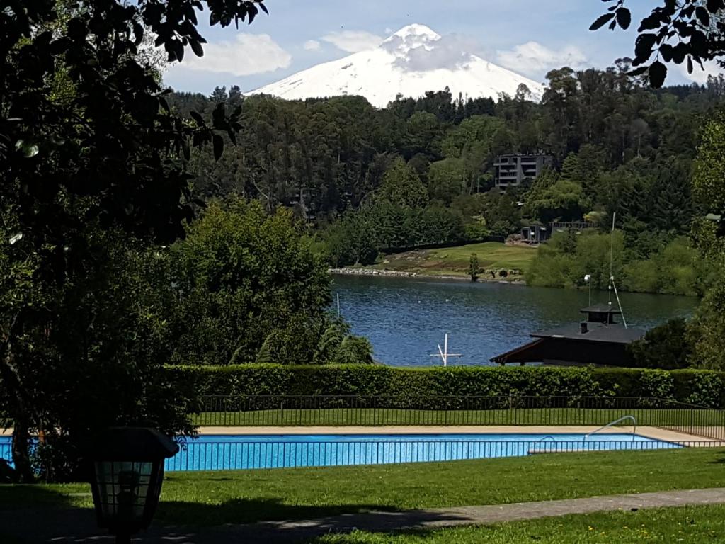 a view of a lake with a snow covered mountain at La Puntilla in Villarrica