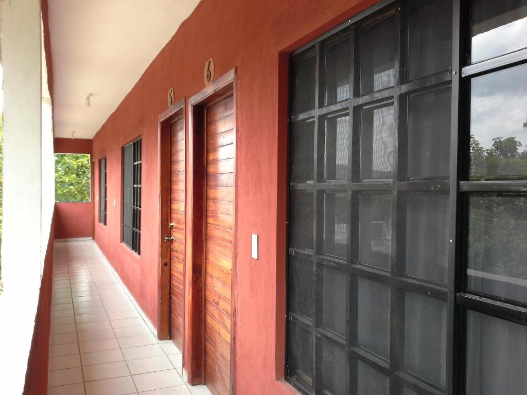 a hallway of a house with red walls and windows at Rincon el Mirador in Tamasopo
