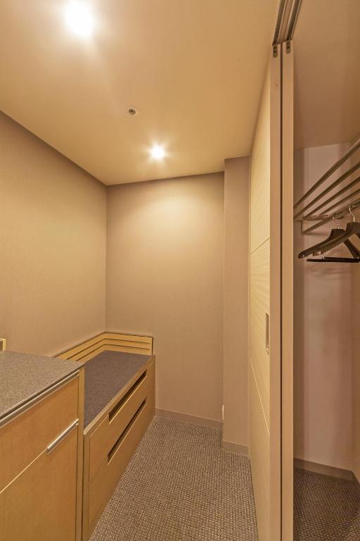 a kitchen with wooden cabinets and a refrigerator at Haneda Excel Hotel Tokyu Haneda Airport Terminal 2 in Tokyo
