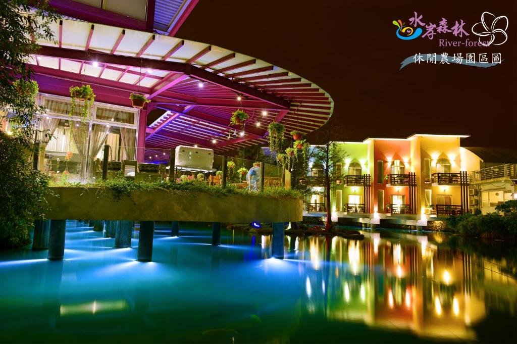 a building with a river in front of it at night at River Forest Leisure Farm in Dongshan