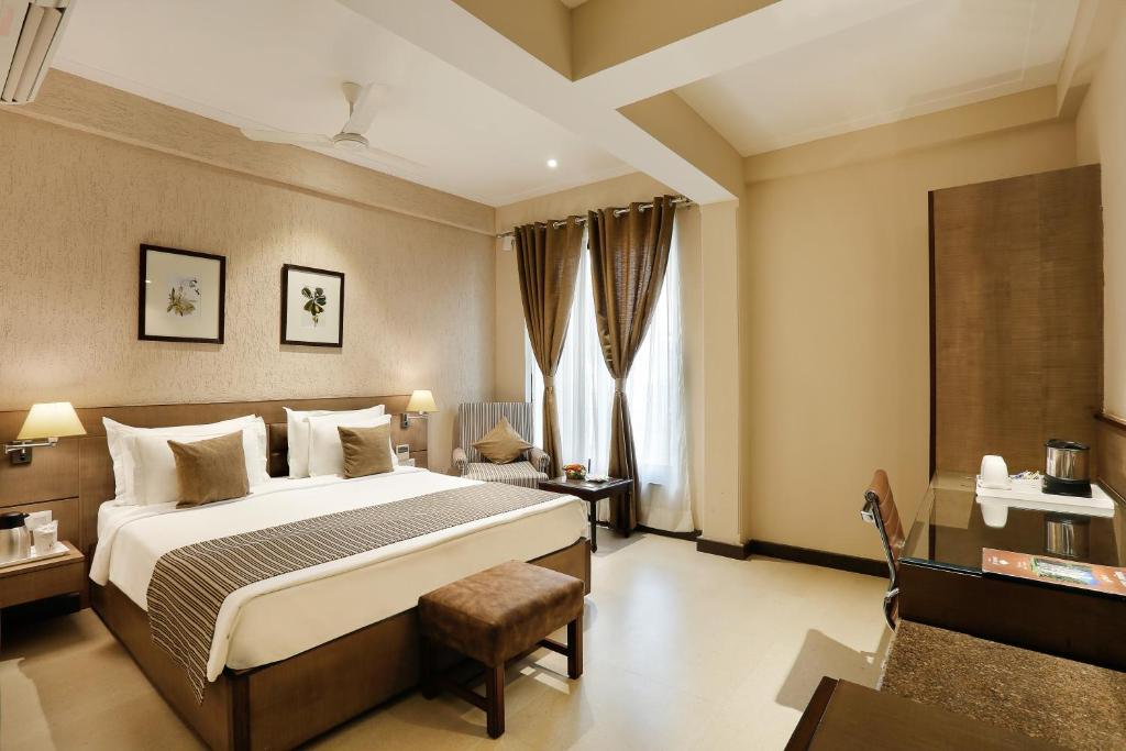 a hotel room with a bed and a chair at The Manor Bareilly by Leisure Hotels in Bareilly