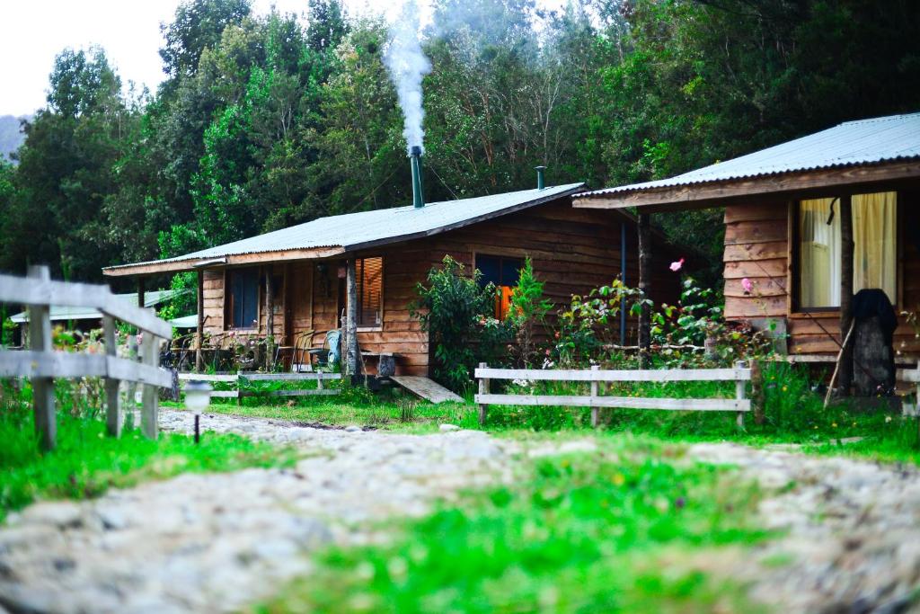 uma cabana de madeira com fumo a sair dela em Entre Esteros Hornopiren em Hornopirén