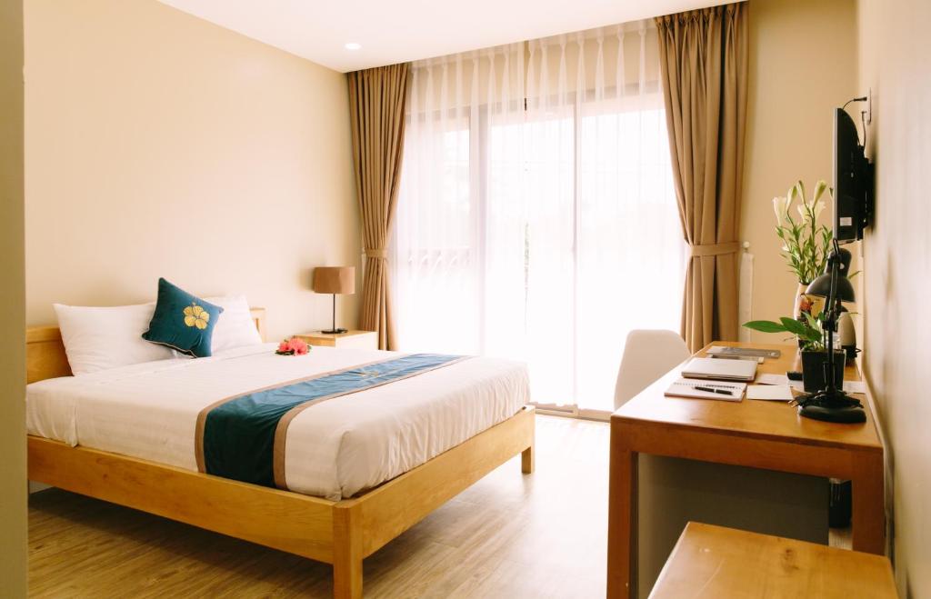 - une chambre avec un lit, un bureau et une fenêtre dans l'établissement Minh Nhung Hotel, à Bảo Lộc
