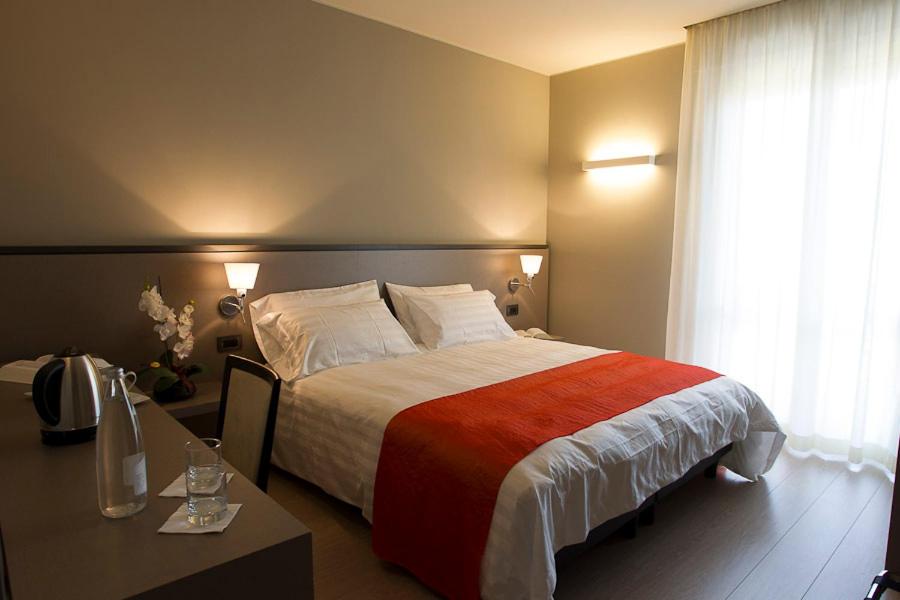 una camera d'albergo con un grande letto e un tavolo di Zara Rooms & Suites a Suzzara